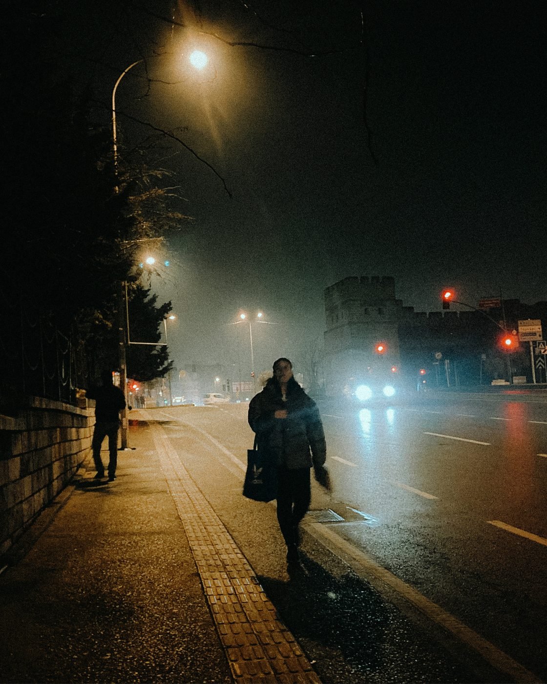 Une personne marche seule dans une rue la nuit sous un lampadaire — pourquoi il est difficile d'intervenir quand on est témoin