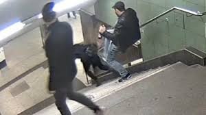 Une agression dans un escalier de métro pendant qu'un témoin s'éloigne sans intervenir — illustration de l'effet témoin